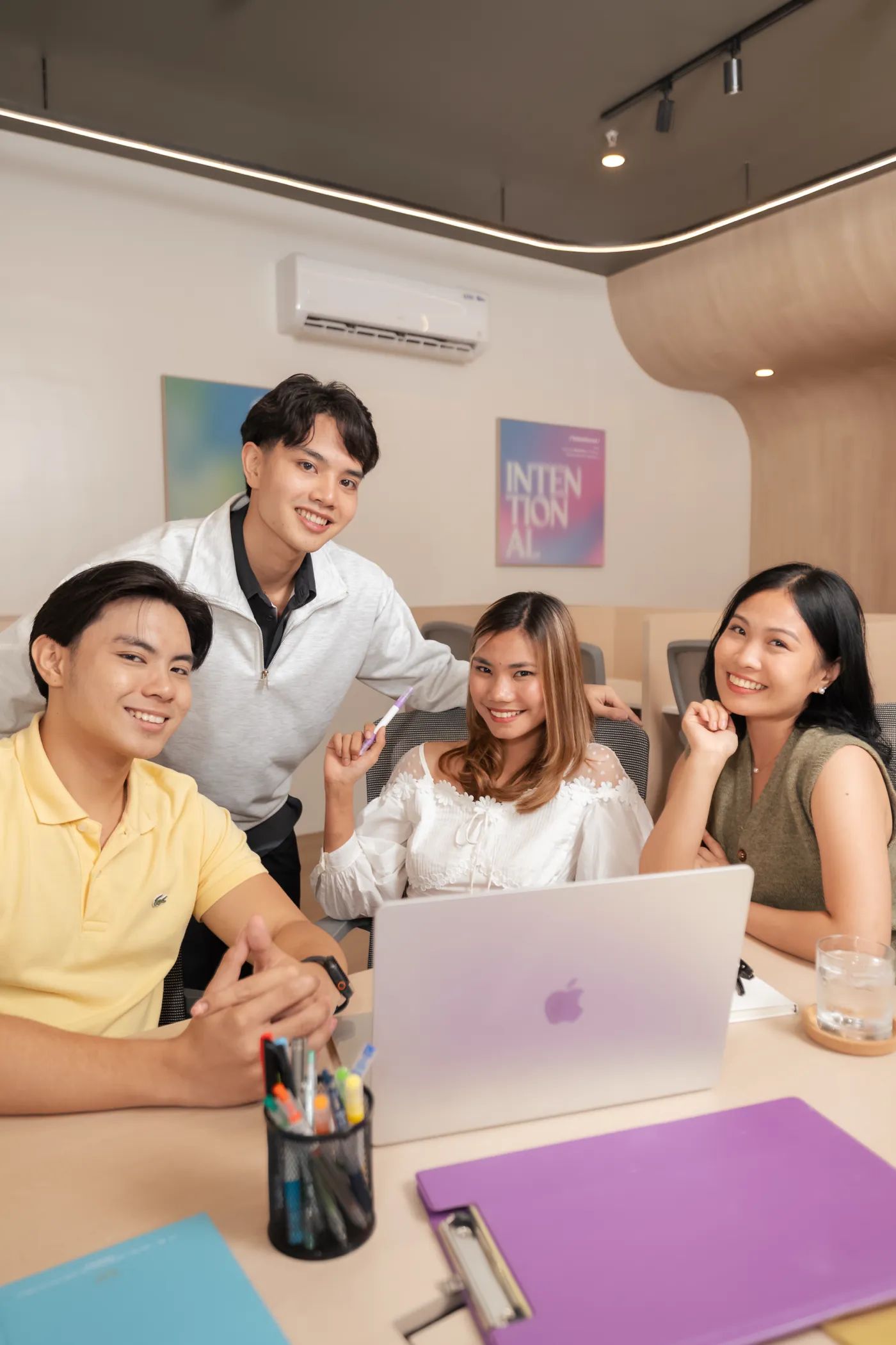 Group of people smiling together inside Mangoes and Bananas coworking space.