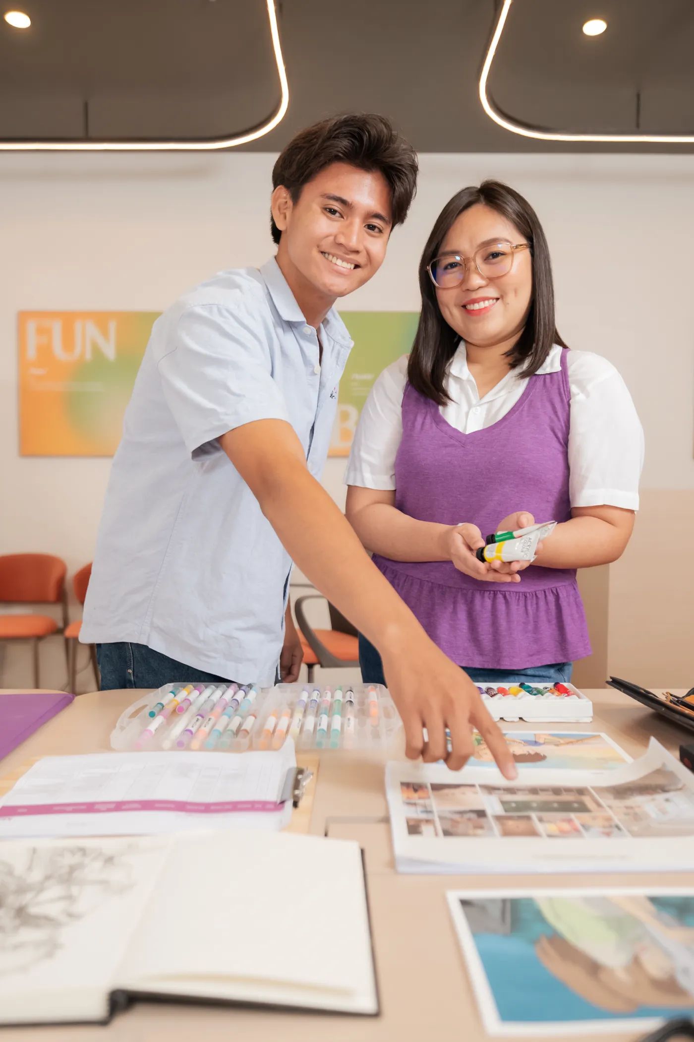 Two people reviewing design materials together inside Mangoes and Bananas Studio.