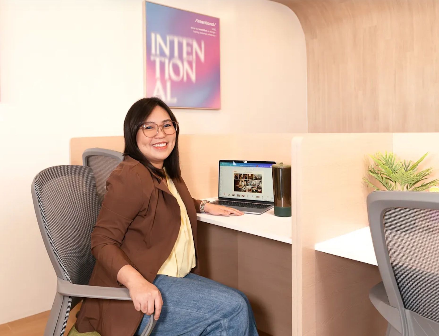 Freelancer working at a desk with a laptop inside Mangoes and Bananas coworking space.