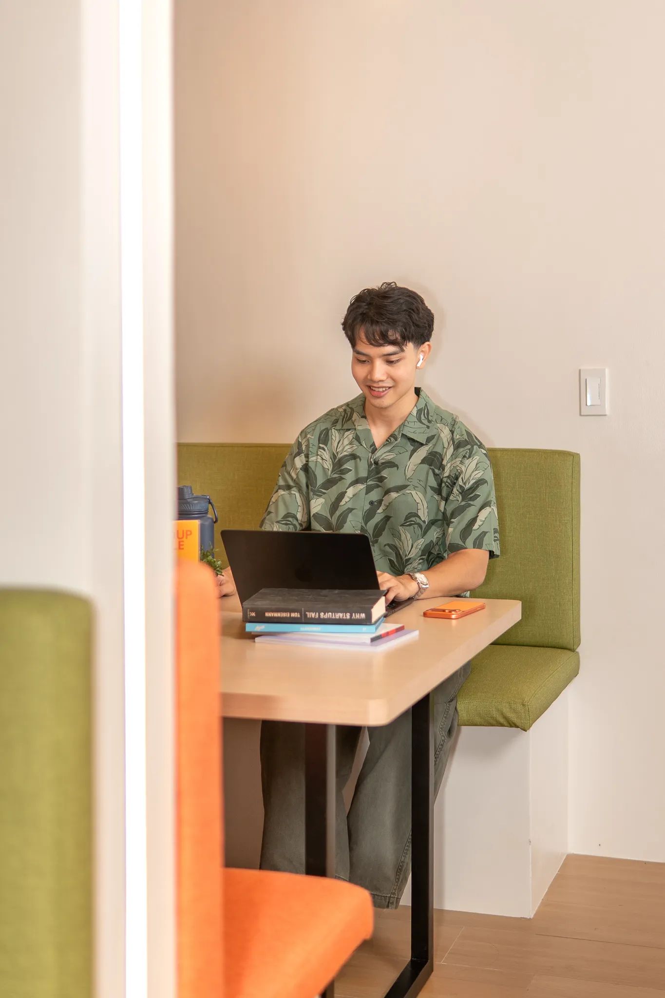 Remote worker using a laptop in a lounge seat inside Mangoes and Bananas coworking space.