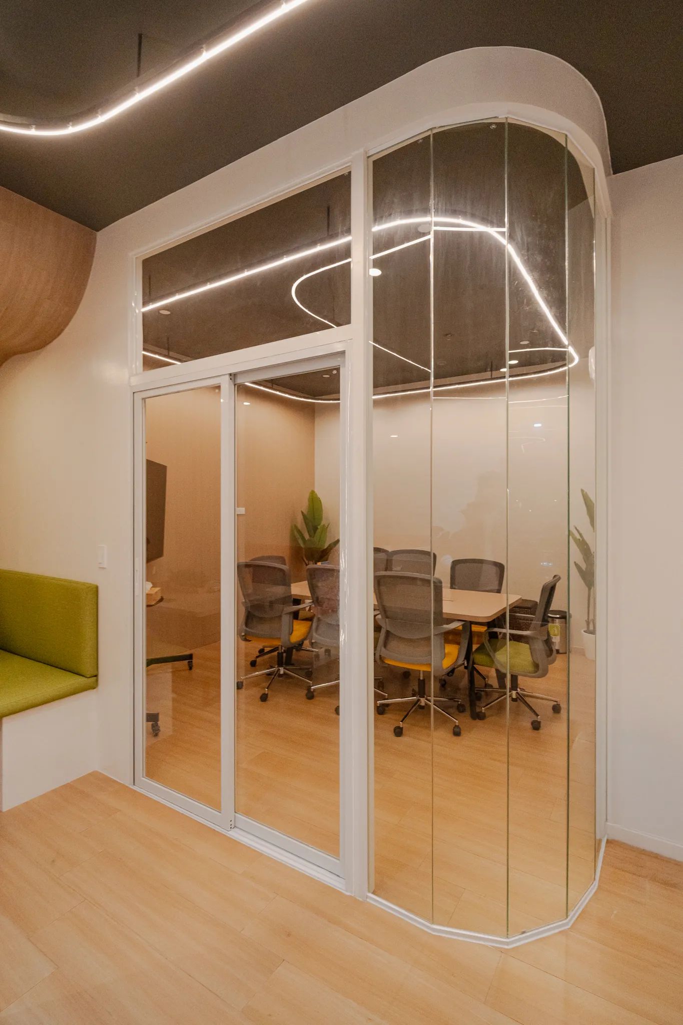 Glass-enclosed meeting room inside Mangoes and Bananas coworking space.